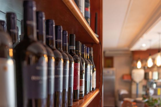 Reihe italienischer Rotweinflaschen im Weinregal