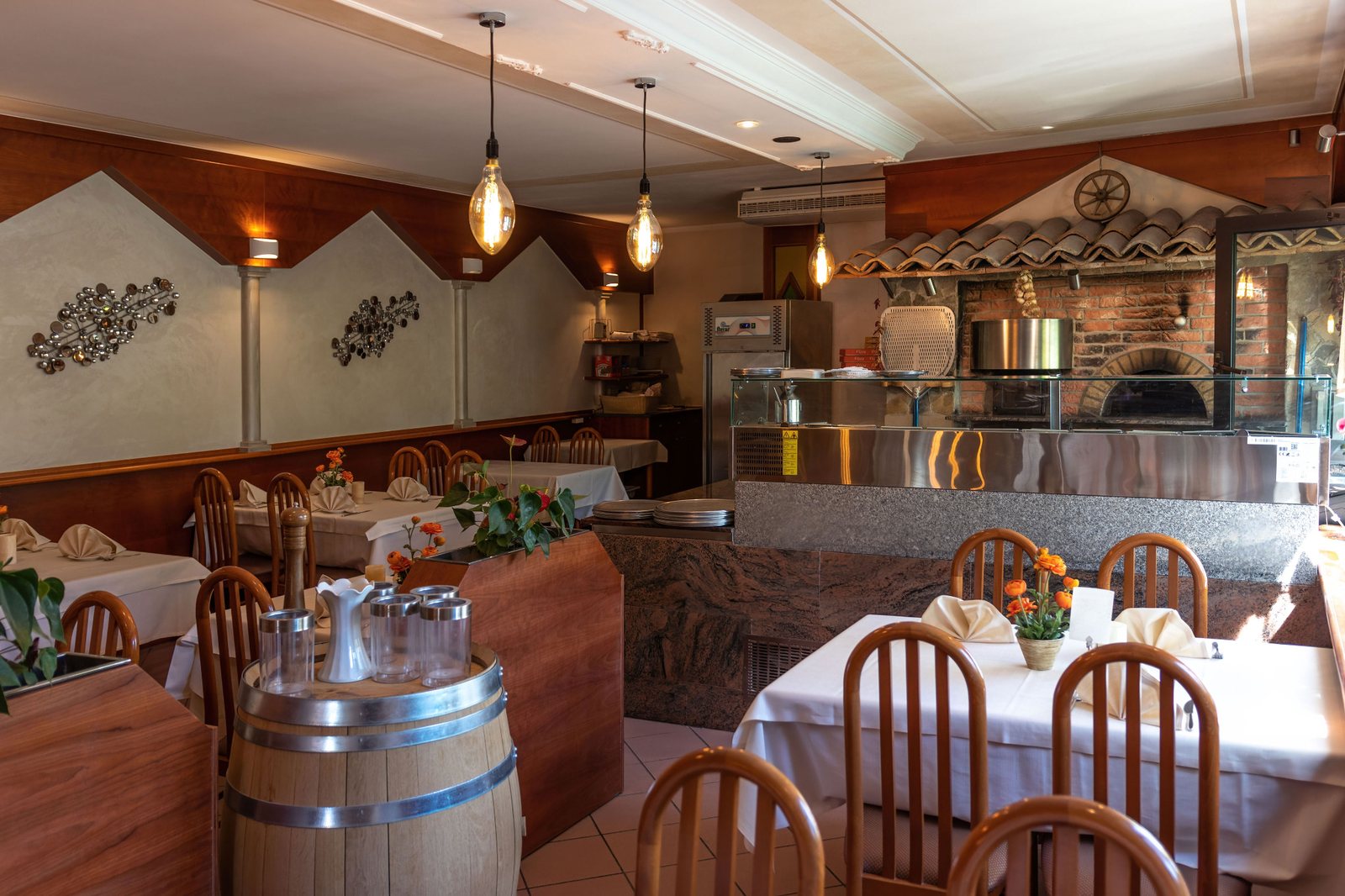 Gastraum des Ristorante San Remo mit gedeckten Tischen und Pizzaofen